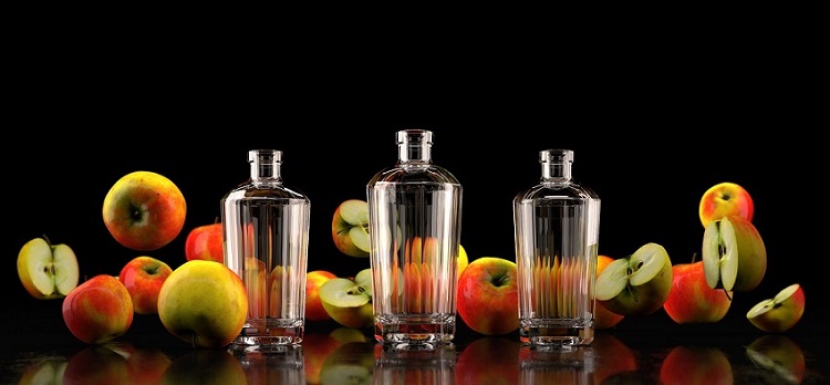 Render fotorealistico di bottiglie di vetro su sfondo nero e mele | Render Superresolution
