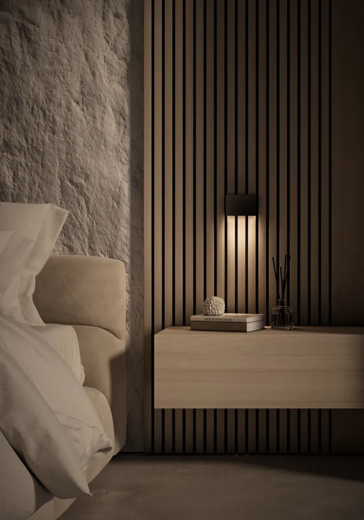 Applique Anda di Cini&Nils su parete in pietra accanto a un letto