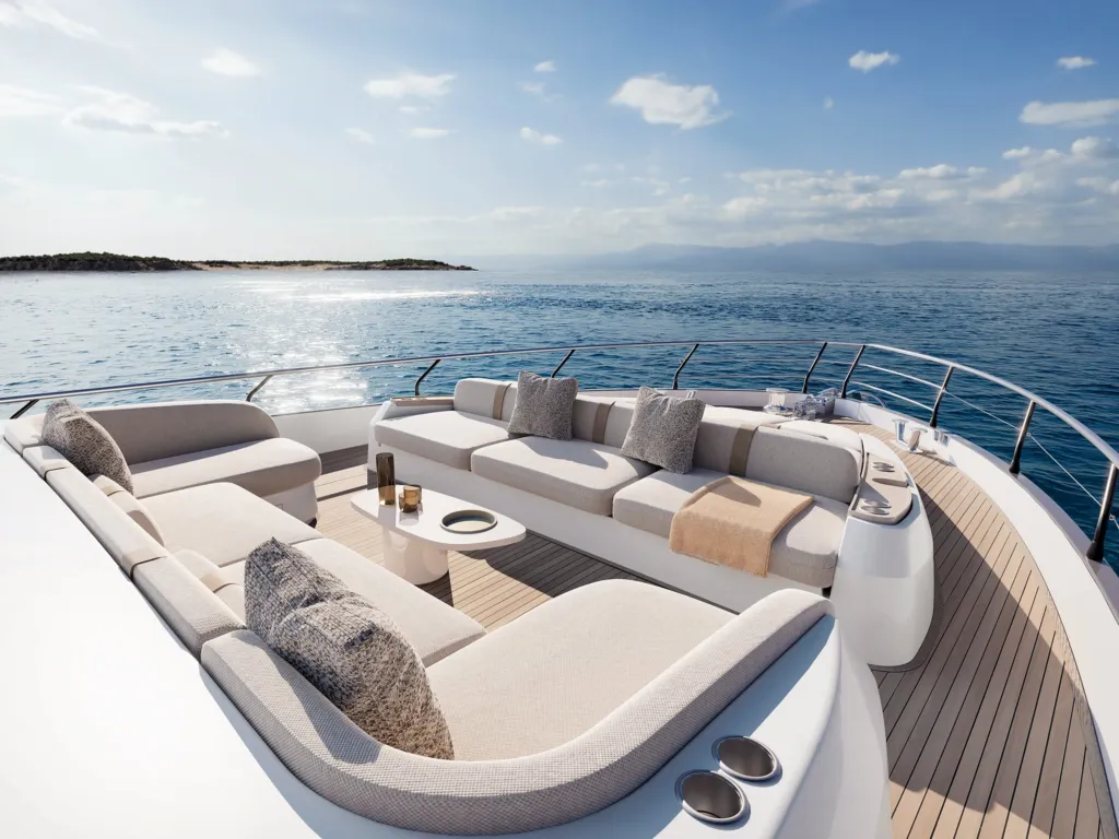 Lounge di prua dell'Azimut Fly 82 con divani bianchi e prendisole affacciati sul mare