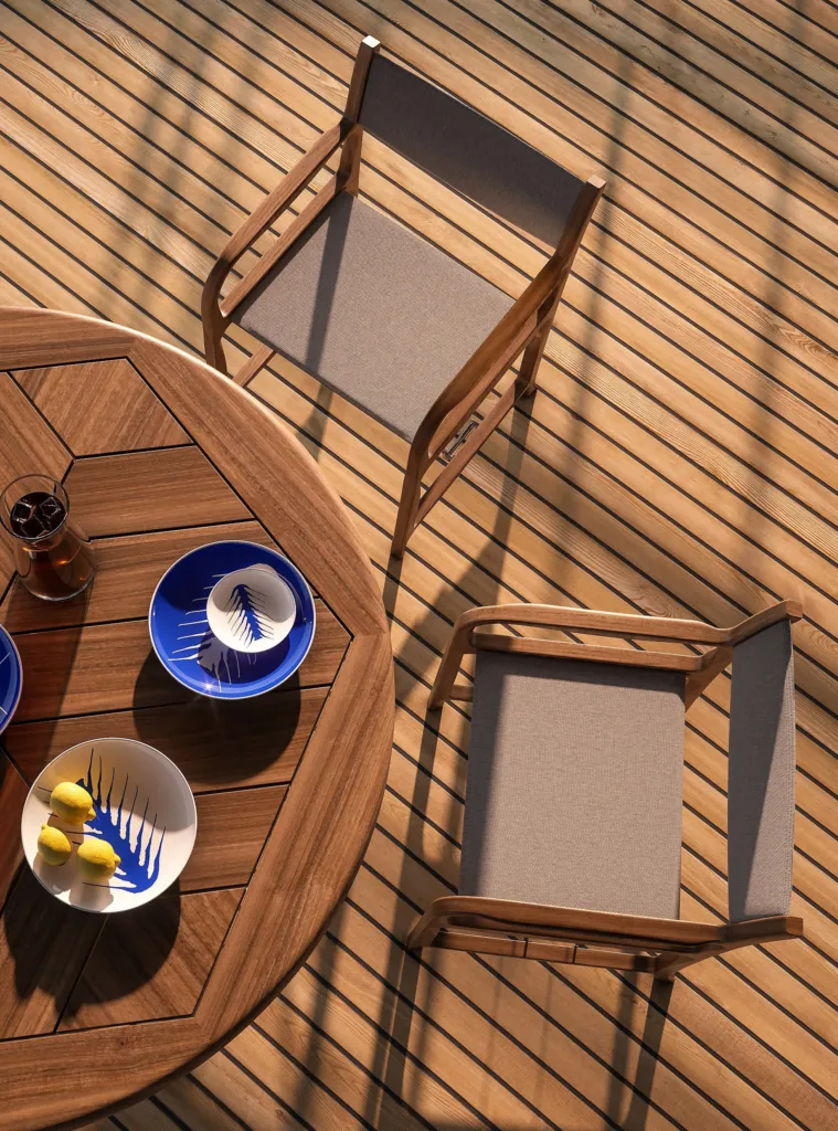 Vista dall'alto di un tavolo e due sedie in teak Cassina sul ponte in legno di uno yacht