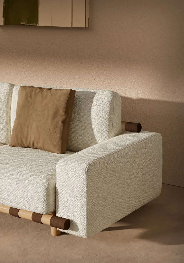 Dettaglio del divano in tessuto bianco con base a listelli in legno