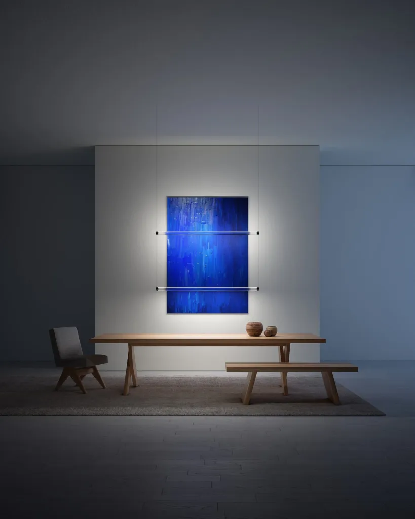 Lampade Magia di Davide Groppi ai lati di un quadro blu sopra un tavolo con panca