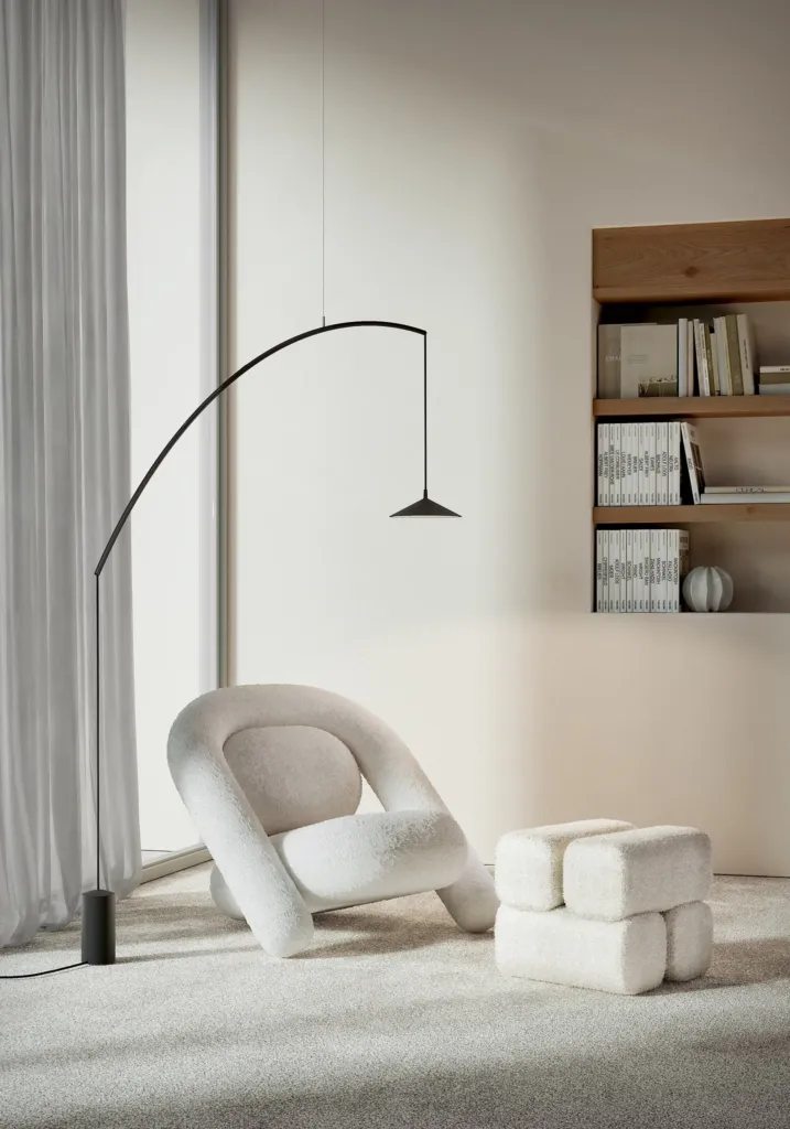 Lampada da terra ad arco Minima di Cini&Nils sopra una poltrona bianca
