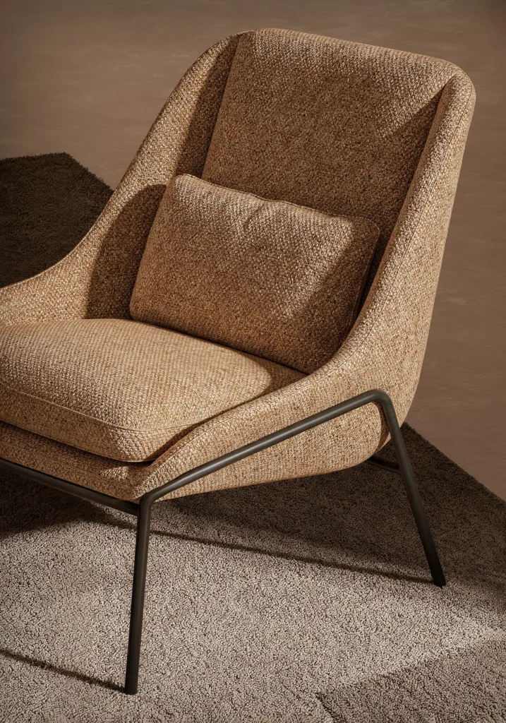 Poltrona lounge in tessuto beige con cuscino e struttura in metallo scuro