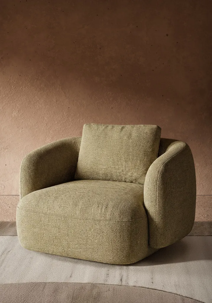 Poltrona in bouclé verde salvia davanti a una parete terracotta