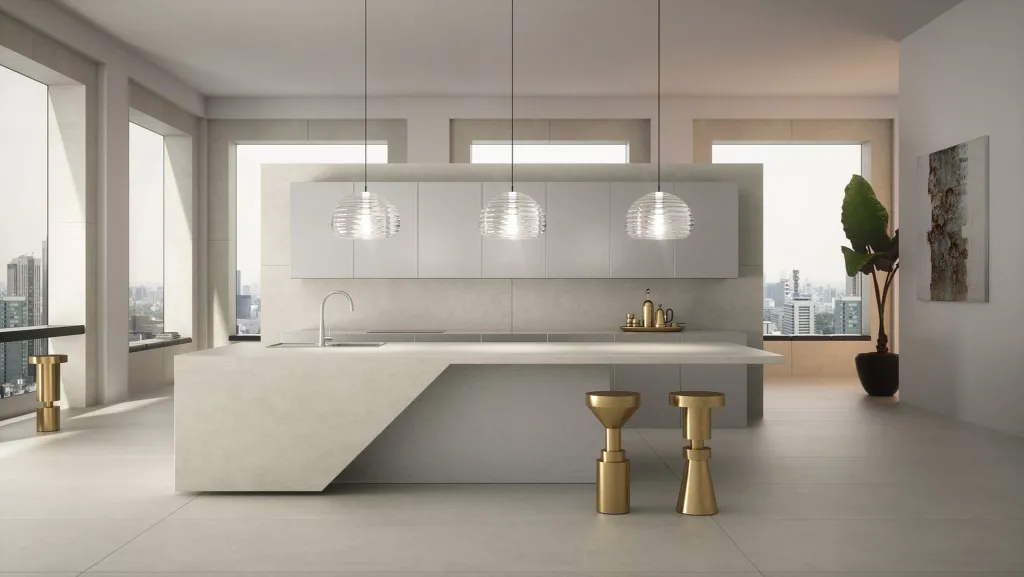 Cucina con isola bianca in lastre Laminam Diamond Collection e lampade a sospensione in vetro